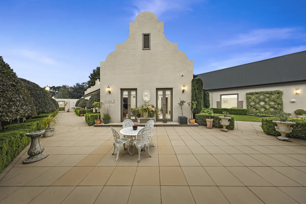 Cape Dutch style home and paved courtyard at dusk &mdash; real estate photography Melbourne