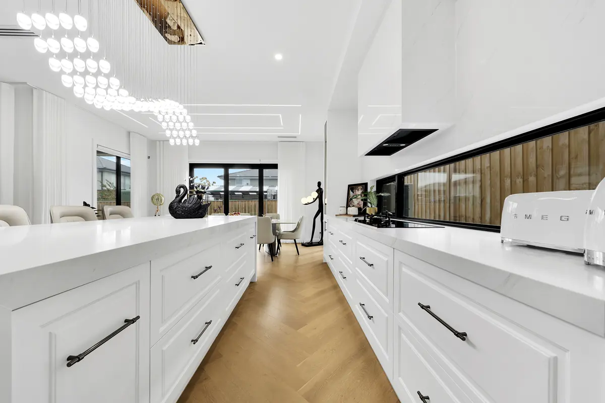 White kitchen with pendant lighting and stone island &mdash; real estate photography Melbourne